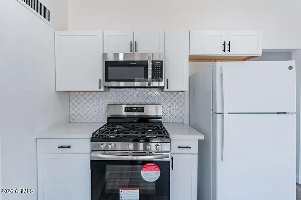 a kitchen with a refrigerator stove and microwave