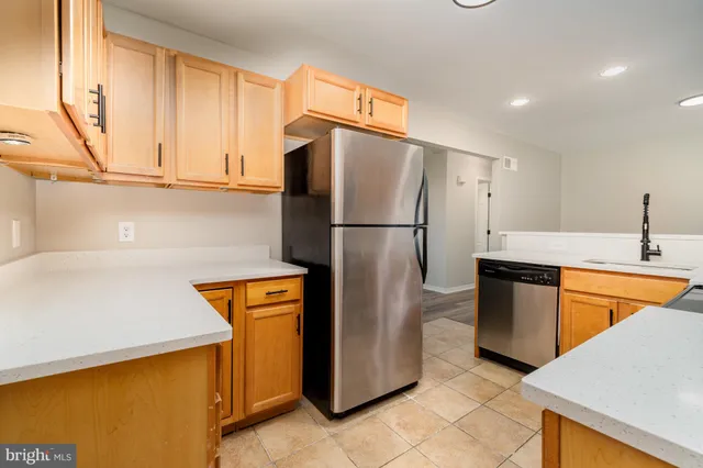 a kitchen with stainless steel appliances granite countertop a refrigerator a sink and a stove