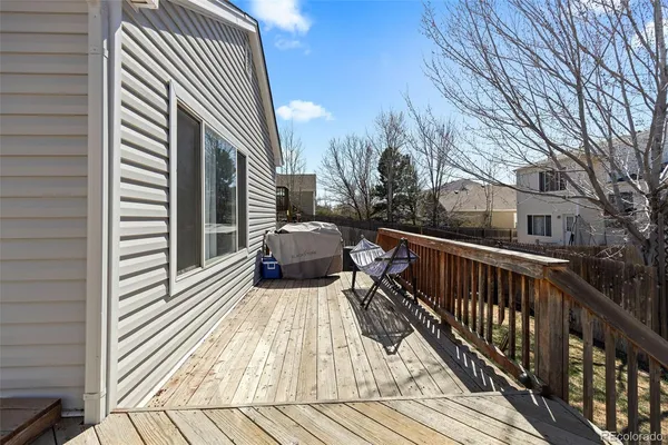 a view of balcony with wooden floor and fence and a bench
