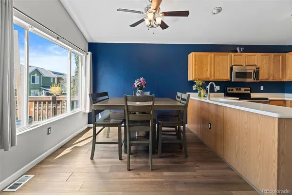 a kitchen with a dining table chairs and white appliances