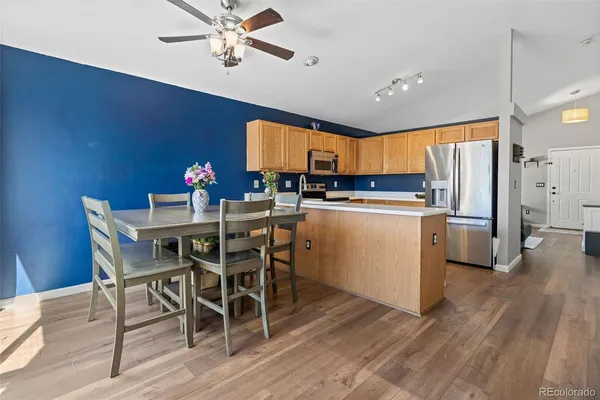 a kitchen with a table chairs refrigerator and cabinets