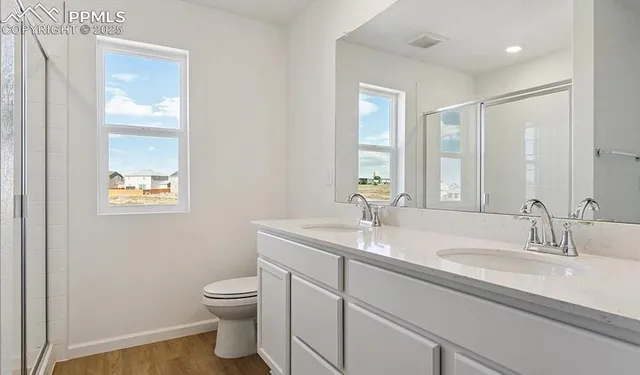 a bathroom with a granite countertop toilet a sink and a mirror