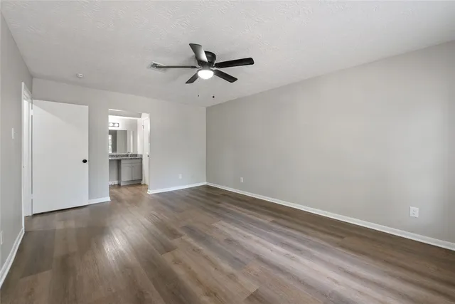 a view of empty room with wooden floor and window