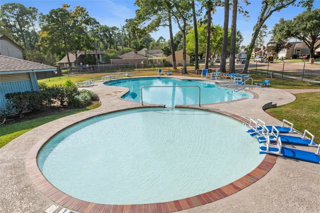 a view of a swimming pool with outdoor seating and plants