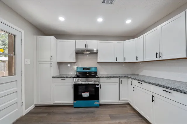 a kitchen with cabinets appliances and a window