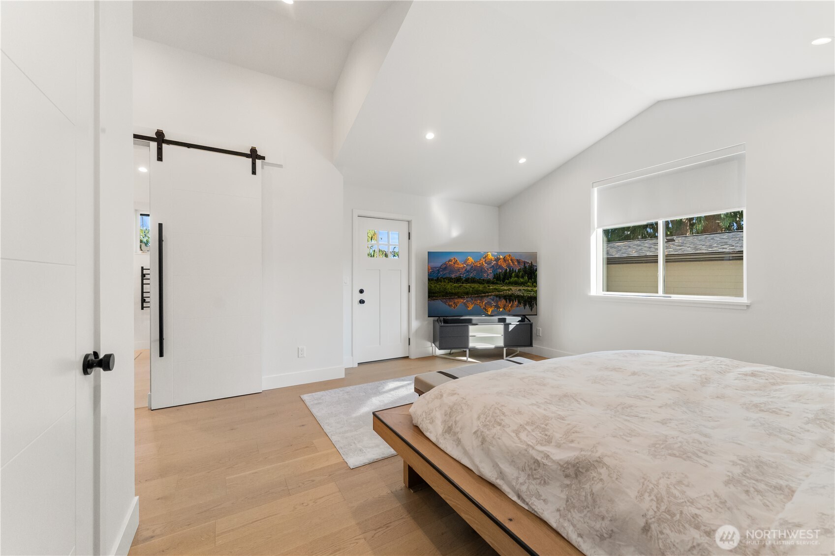 509 North 78th Street Seattle, WA 98103 - Photo 23 of 37 a room with a bed window and a flat screen tv