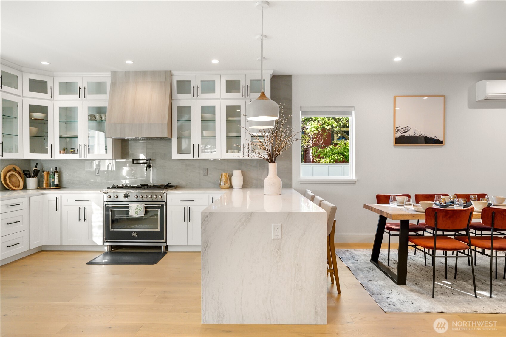 509 North 78th Street Seattle, WA 98103 - Photo 10 of 37 a kitchen with stainless steel appliances granite countertop a stove top oven a sink a dining table and chairs with wooden floor