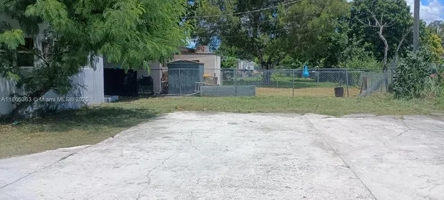 a view of a house with a yard and large tree