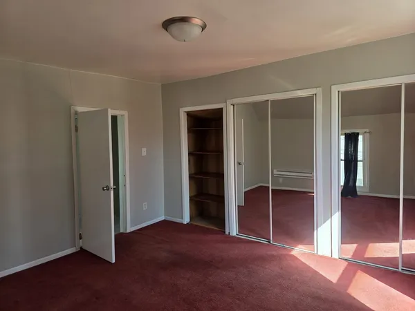 an empty room with closet and wooden floor