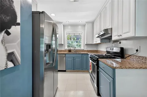 a kitchen with stainless steel appliances granite countertop a stove a sink and a refrigerator