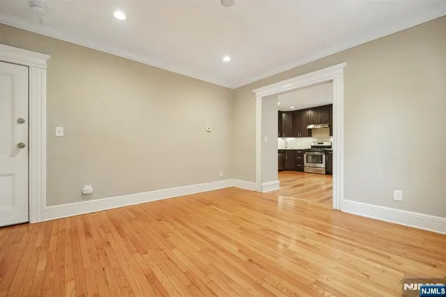 a view of empty room with wooden floor