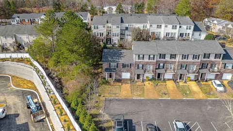 an aerial view of a house with swimming pool and large trees