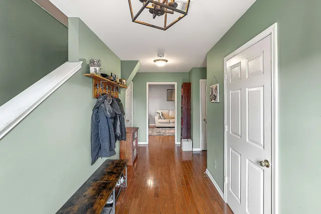 a view of a hallway with wooden floor and closet