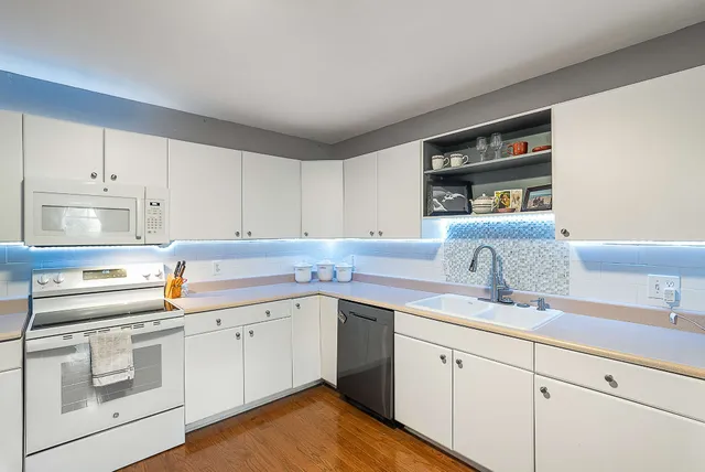 a kitchen with a sink dishwasher stove and cabinets