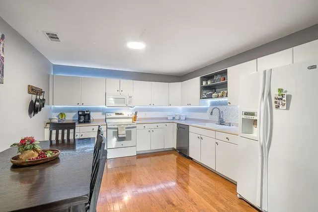 a kitchen with white cabinets and appliances