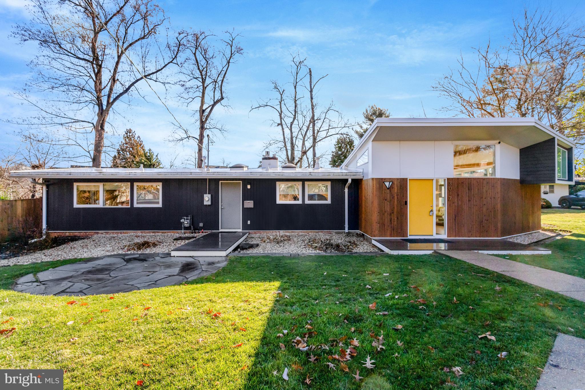 a front view of a house with a yard and trees