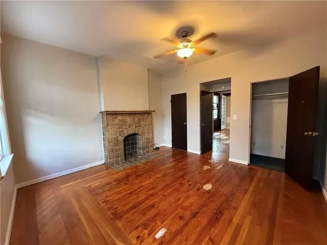 a view of empty room with wooden floor and fireplace