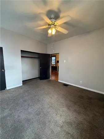 a view of an empty room with a ceiling fan