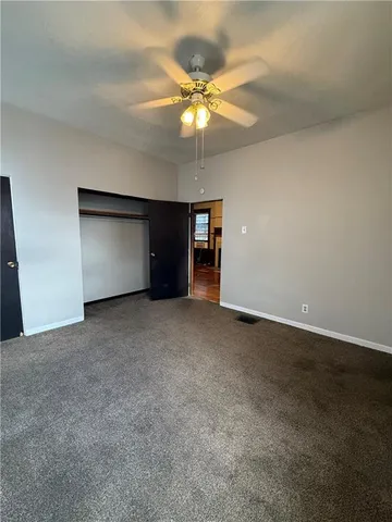 a view of an empty room with a ceiling fan