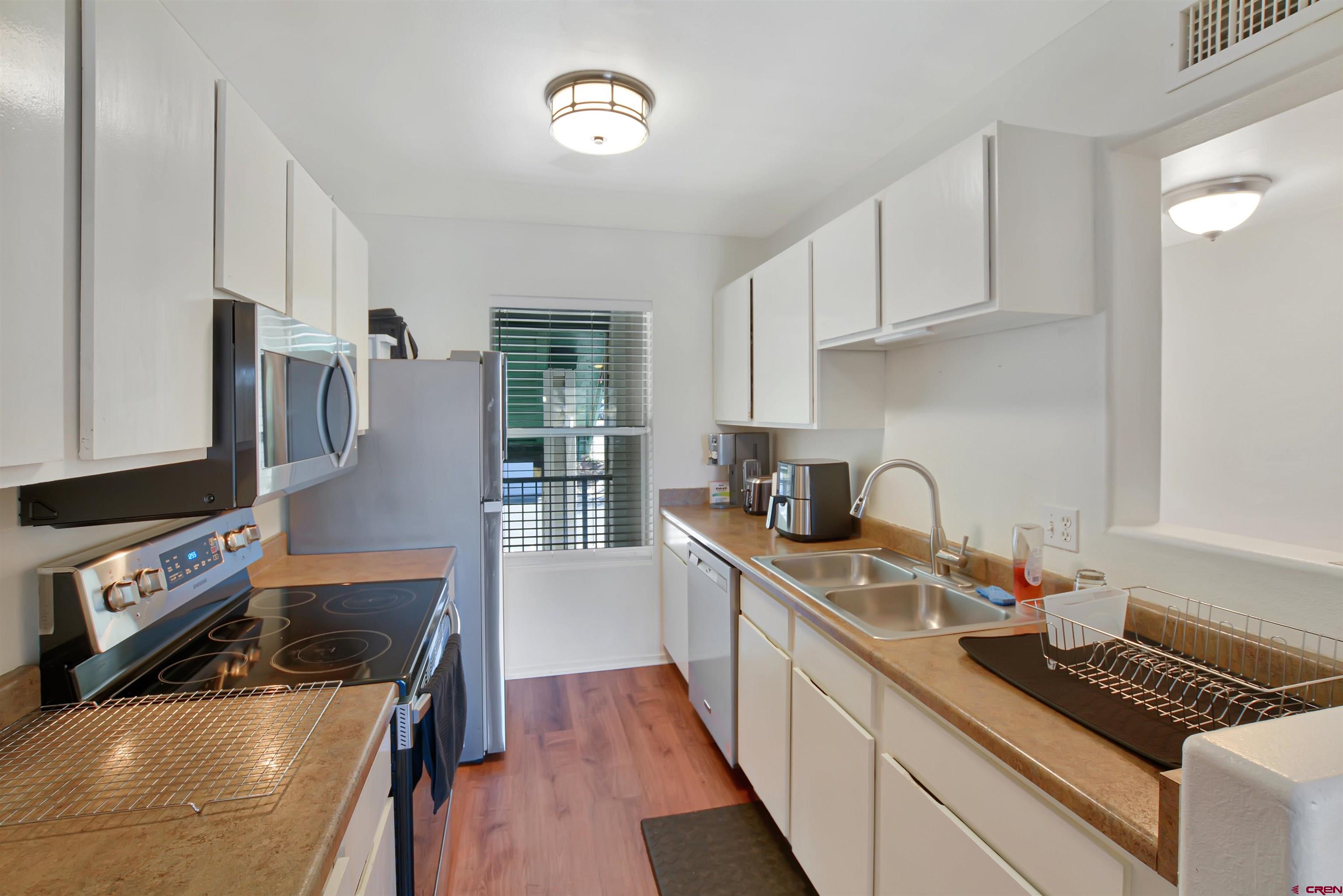 1100 Goeglein Gulch Road, Unit 223 Durango, CO 81301 - Photo 14 of 25 a kitchen with stainless steel appliances granite countertop a sink stove and refrigerator