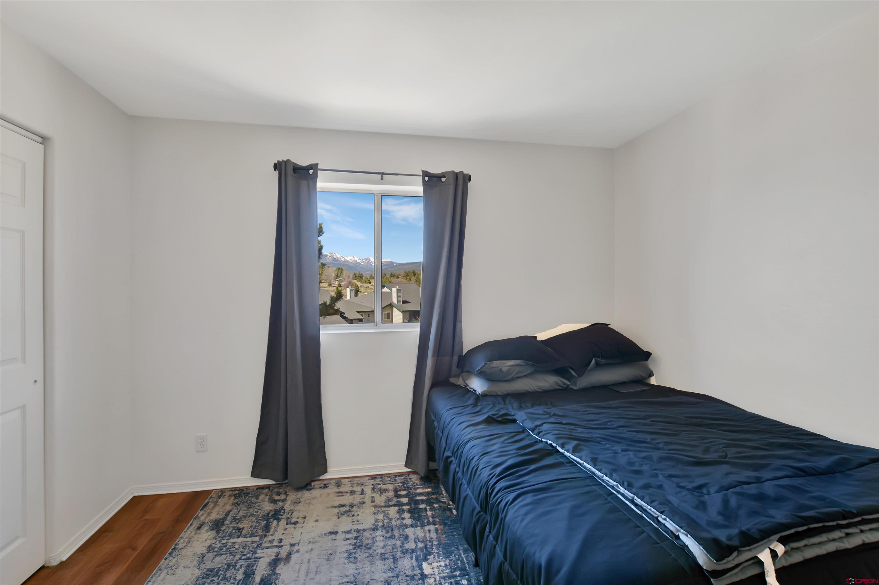 1100 Goeglein Gulch Road, Unit 223 Durango, CO 81301 - Photo 3 of 25 a bed sitting in a bedroom and wooden floor