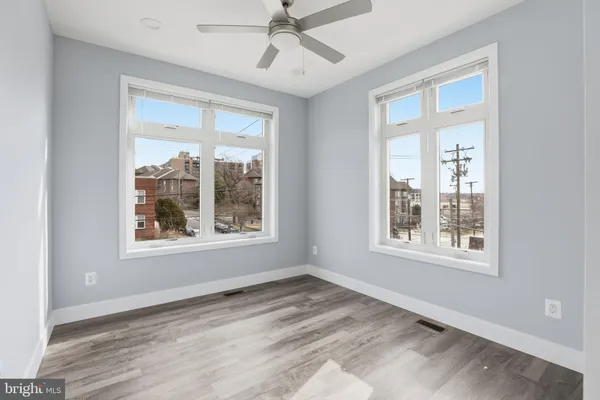 a view of a hallway with wooden floor and a ceiling fan