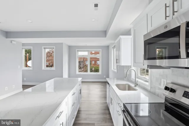 a kitchen with a sink a stove and microwave