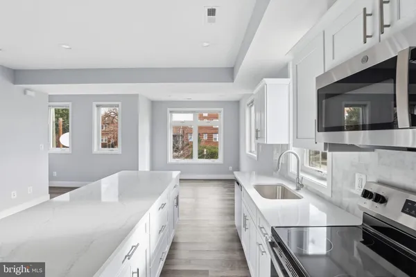 a kitchen with a sink a stove and microwave