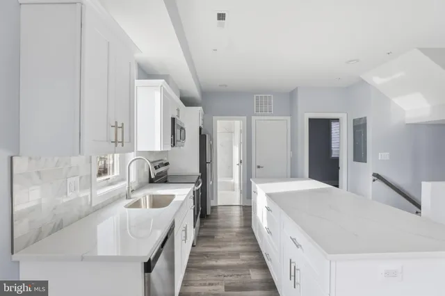 a large white kitchen with cabinets and sink