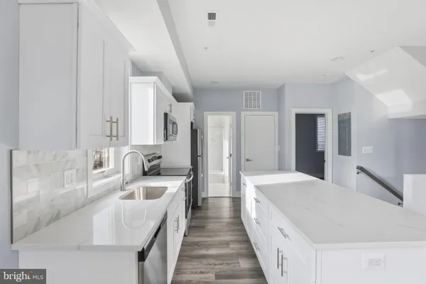 a large white kitchen with cabinets and sink