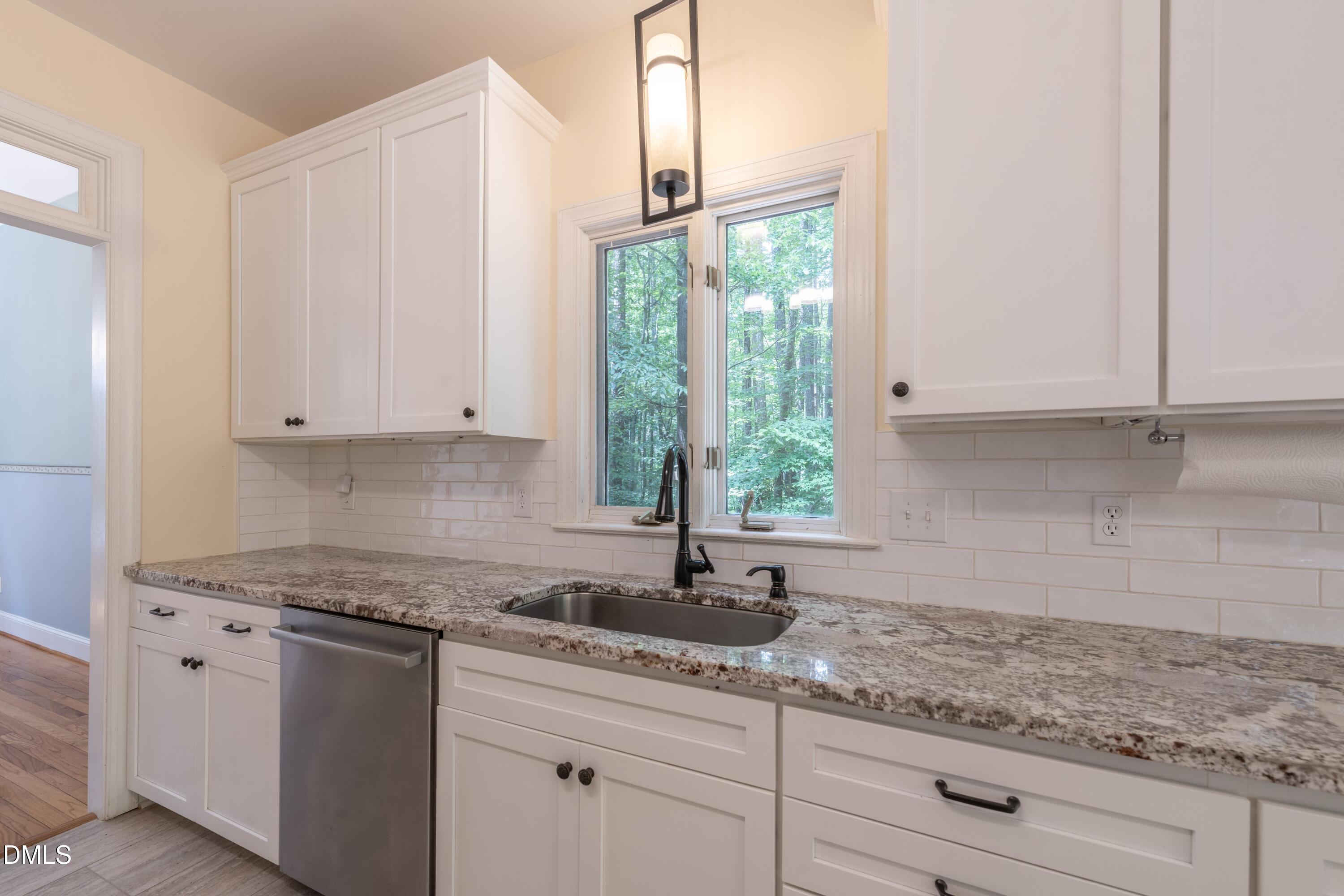 6832 Cool Pond Road Raleigh, NC 27613 - Photo 8 of 27 a kitchen with granite countertop white cabinets and a window
