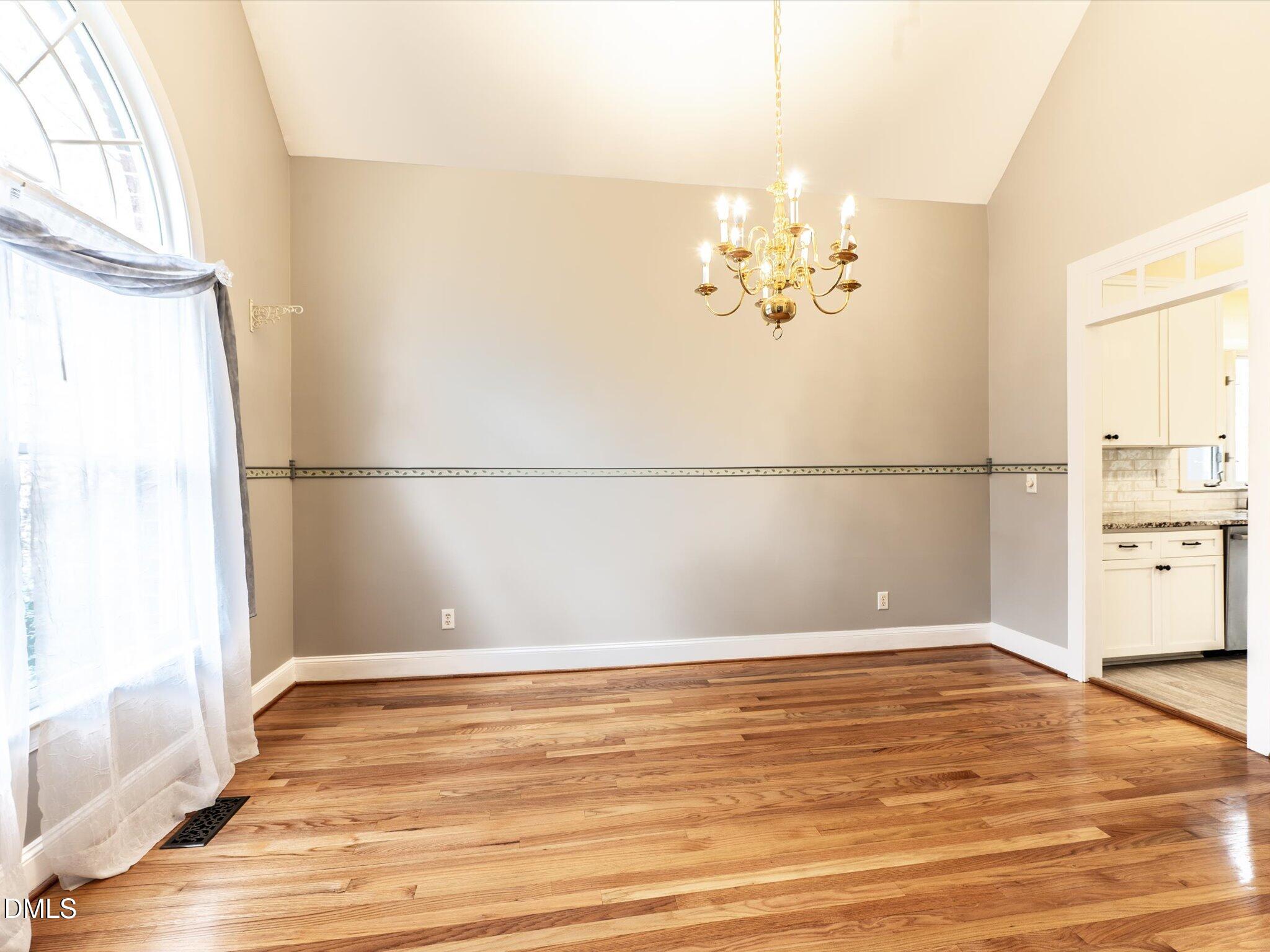 6832 Cool Pond Road Raleigh, NC 27613 - Photo 10 of 27 a view of a room with wooden floor and a chandelier
