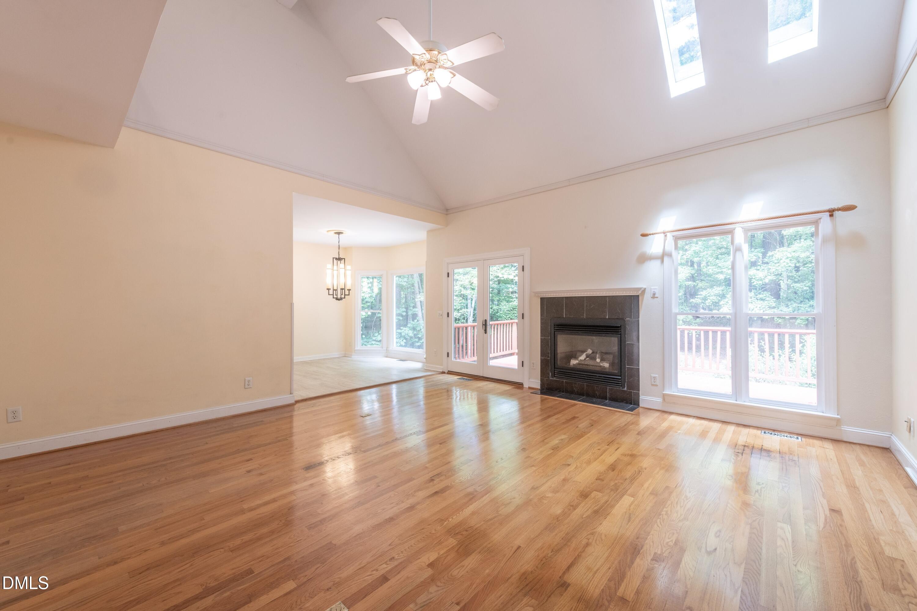 6832 Cool Pond Road Raleigh, NC 27613 - Photo 5 of 27 a view of empty room with wooden floor and fireplace