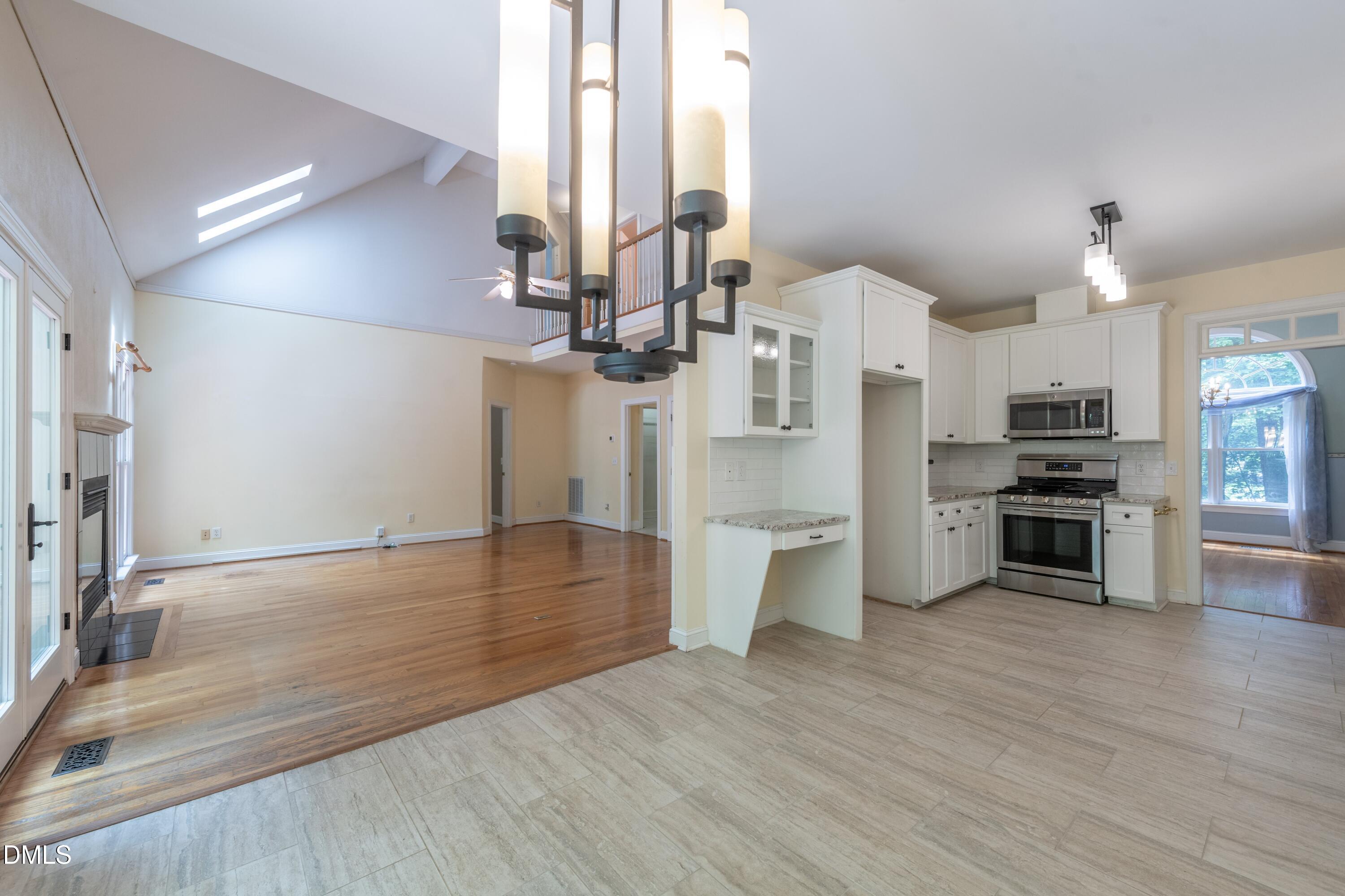 6832 Cool Pond Road Raleigh, NC 27613 - Photo 7 of 27 a view of a kitchen with a sink and dishwasher a stove top oven with wooden floor
