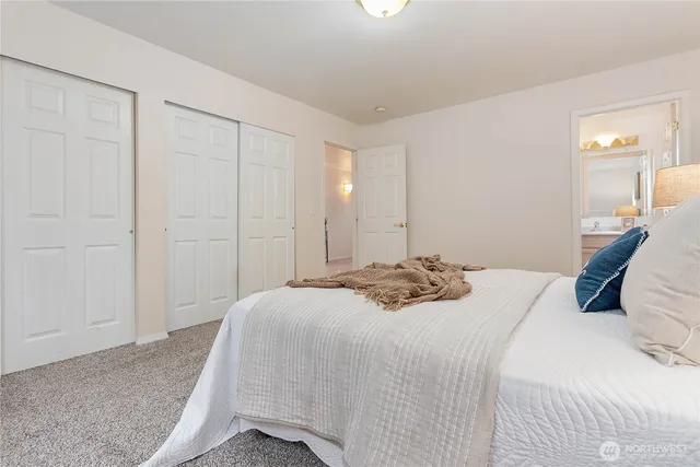 a bedroom with a bed and painting on the wall