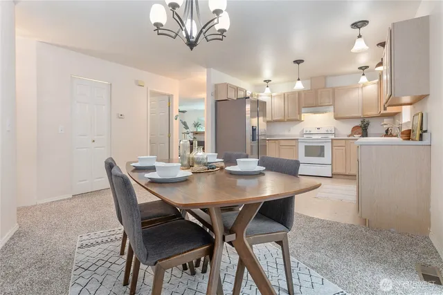 a view of a dining room and kitchen with a table chairs
