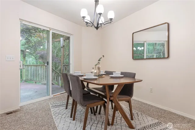a view of a dining room with furniture a chandelier and wooden floor