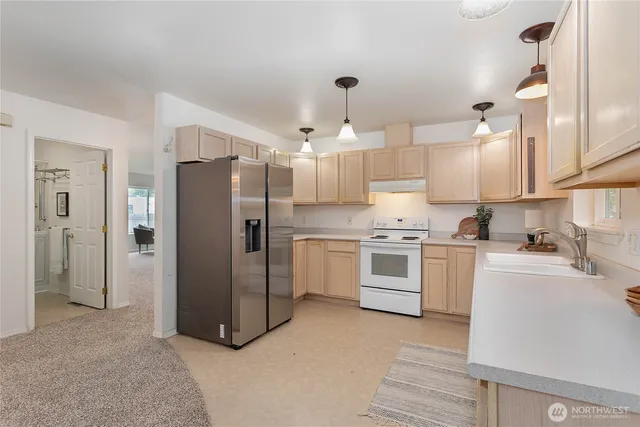 a kitchen with stainless steel appliances a refrigerator sink and cabinets