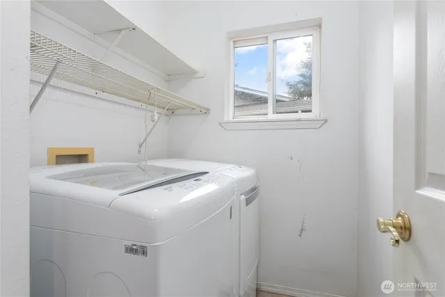a utility room with dryer and window