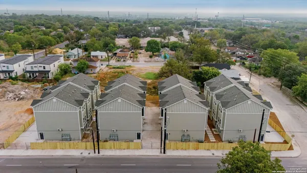 an aerial view of residential houses with outdoor space and parking
