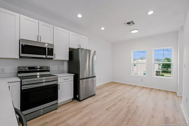 a kitchen with a refrigerator stove and microwave