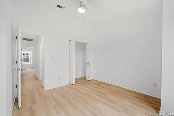 a view of a room with wooden floor and a bathroom