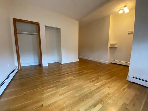 a view of empty room with wooden floor