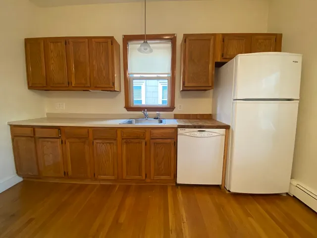 a kitchen with a refrigerator sink stove and cabinets