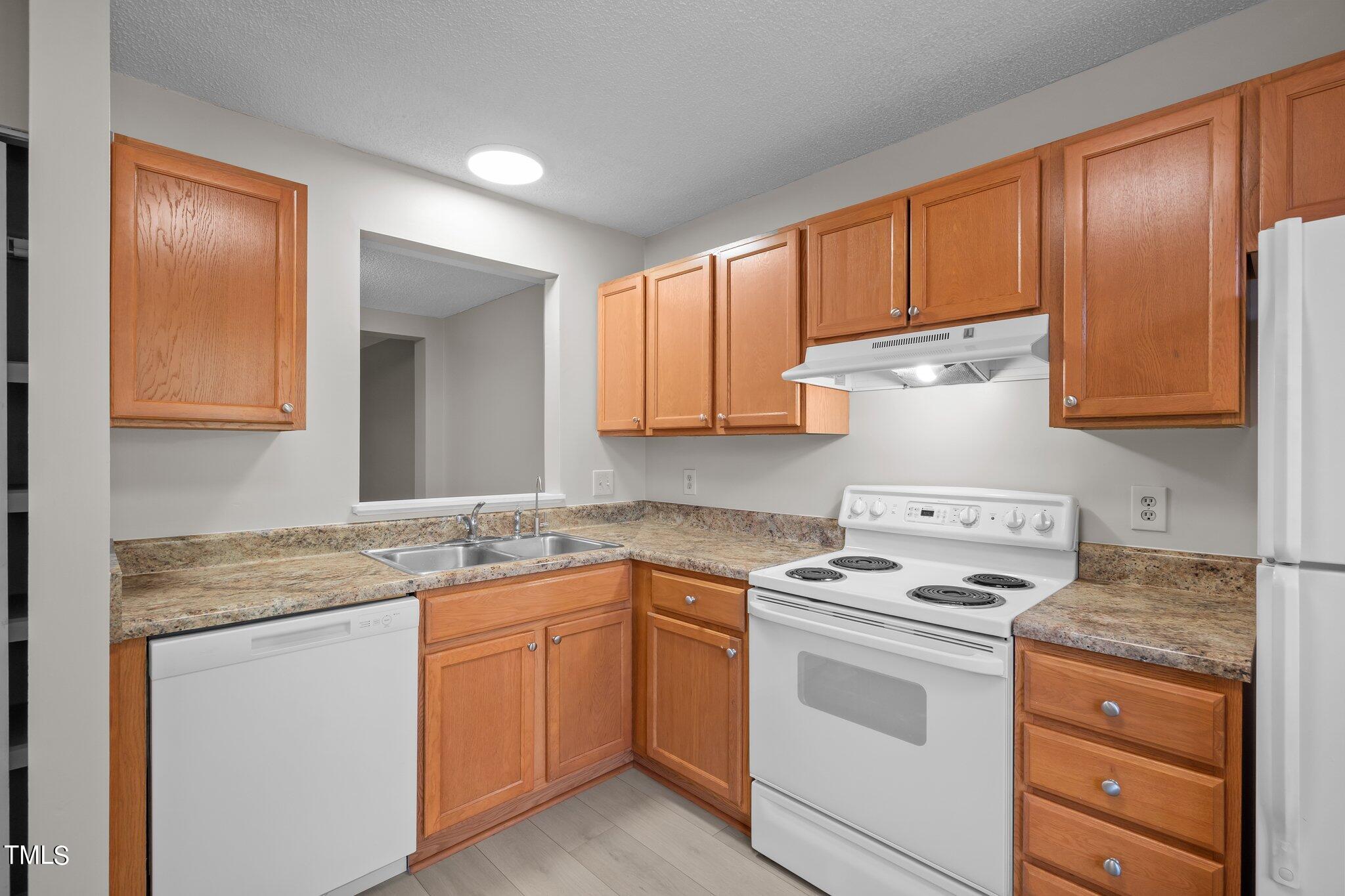 7837 Stephanie Lane Raleigh, NC 27615 - Photo 3 of 27 a kitchen with granite countertop cabinets stainless steel appliances a sink and wooden floor