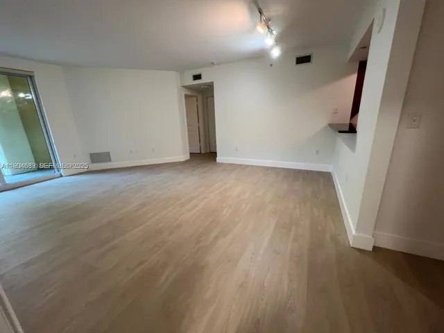 an empty room with wooden floor and a window