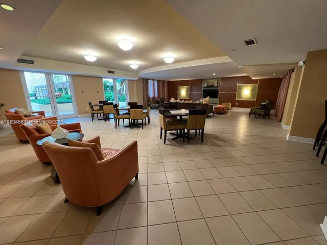 a living room with couches and kitchen view with wooden floor