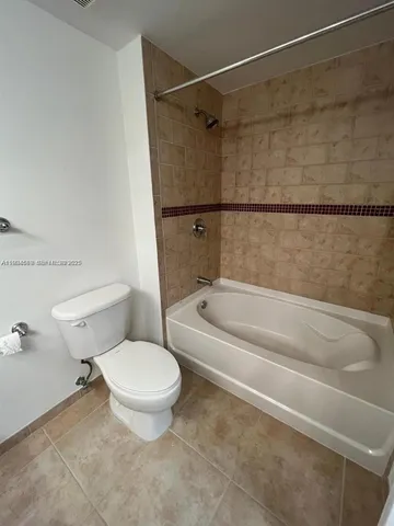 a white toilet sitting next to a bath tub and a shower