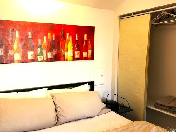 a bedroom with a bed and a wall painting