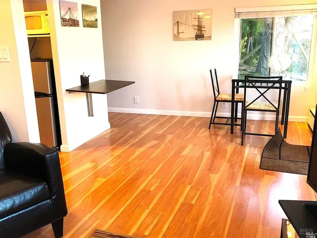a view of a room with furniture and wooden floor